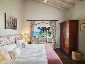 View of Upstairs Beachfront Bedroom looking out to the covered terrace and Caribbean Sea.