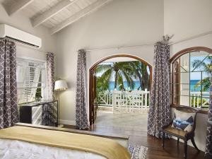View of Upstairs Primary Bedroom With King Sized Bed and views out to the Caribbean Sea